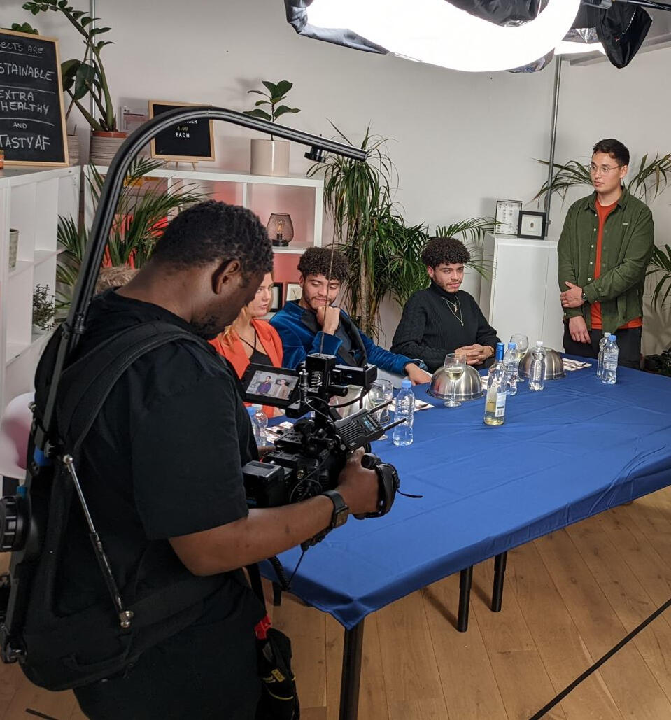 A camera operator shooting a dinner party.